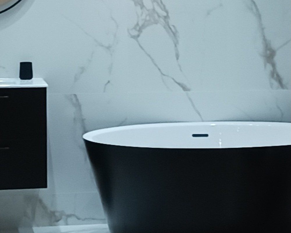 Salle de bains avec baignoire noire et mur effet marbre
